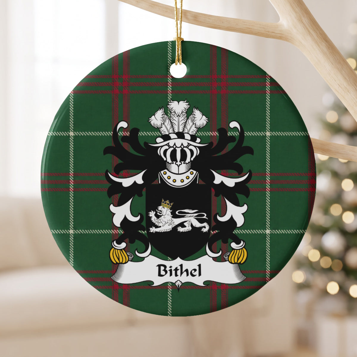 Bithel ornament hanging from a pale wooden branch; a white reclining lion with a gold crown on black on Welsh national tartan.