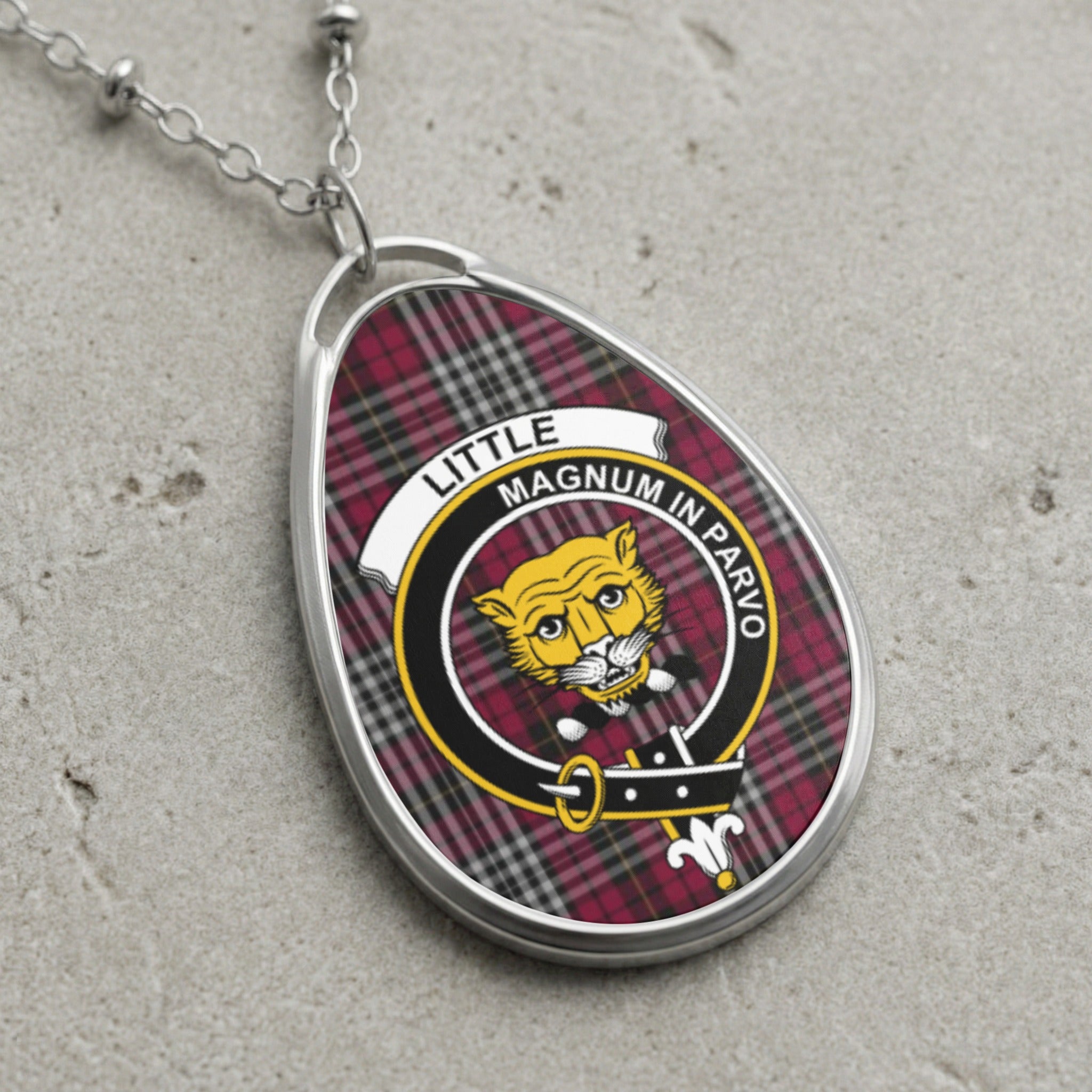 Little clan Scottish tartan necklace with clan crest and Magnum in Parvo motto on tartan background