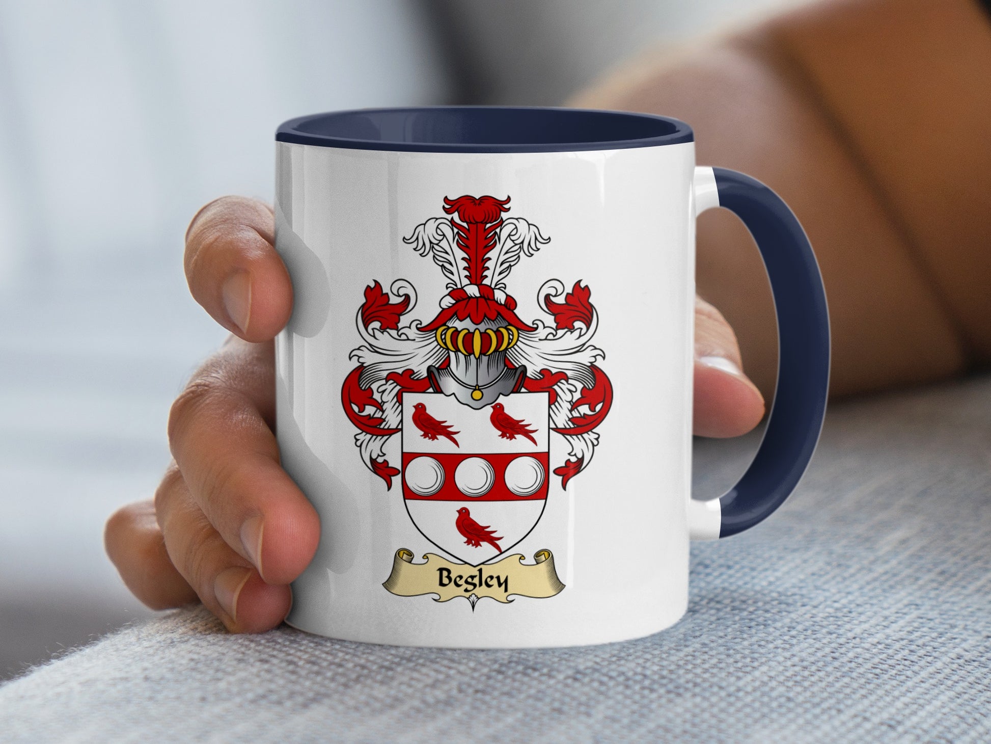 White mug with navy handle featuring a coat of arms with banner that says "Begley".