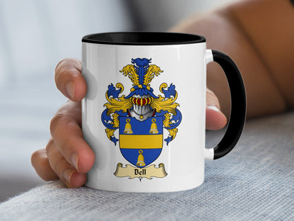 White mug with black rim featuring a gold and blue Bell family crest.