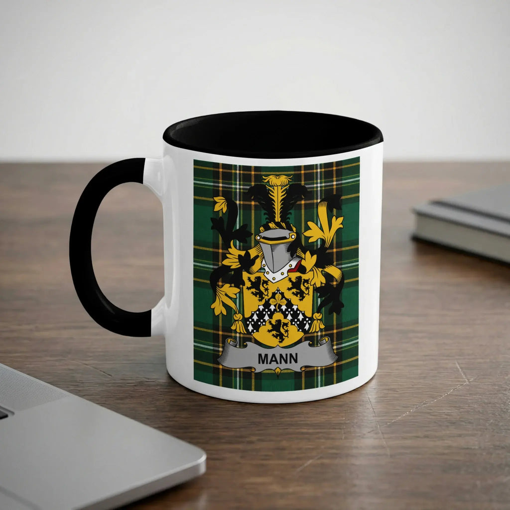 White mug with black rim featuring the Mann family crest on a tartan background.