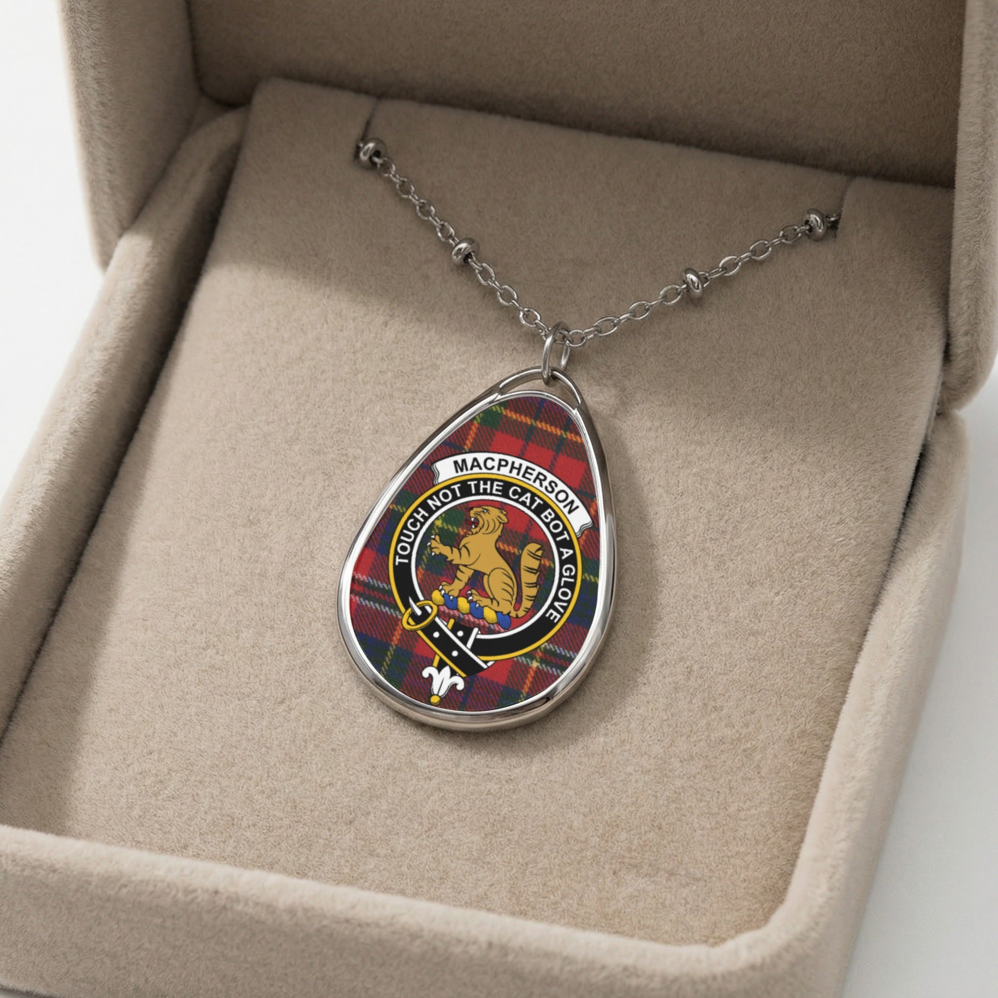 Macpherson clan crest oval pendant with tartan pattern and motto.