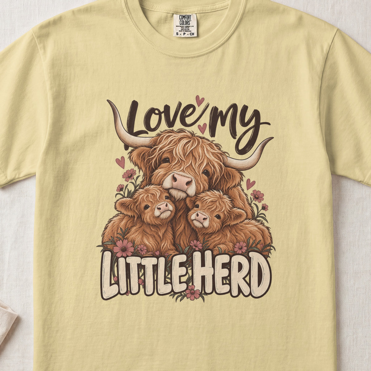 Love My Little Herd Highland cow design on a Butter Comfort Colors 1717 T-shirt, flat lay