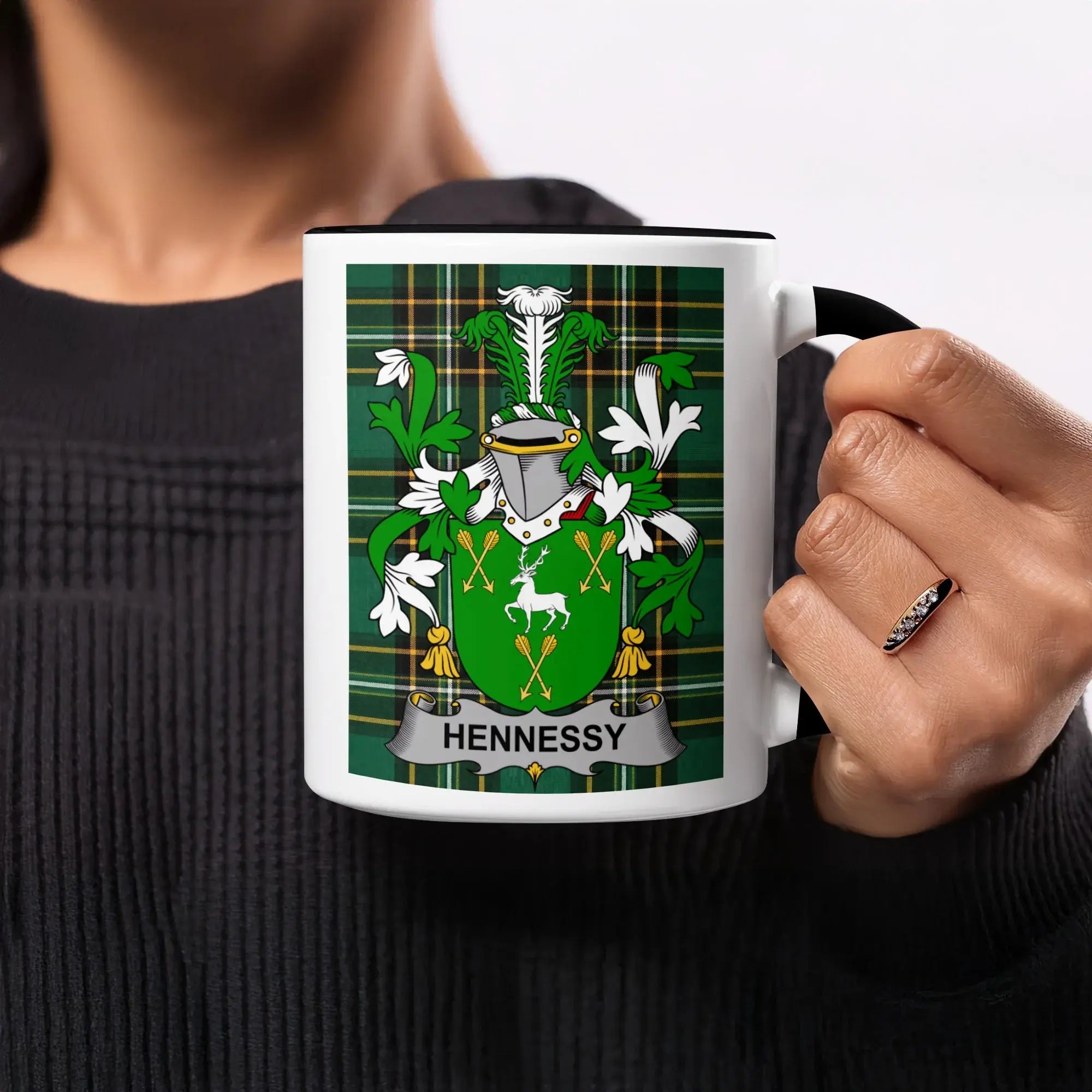 White mug with Hennessy family crest on green plaid background.