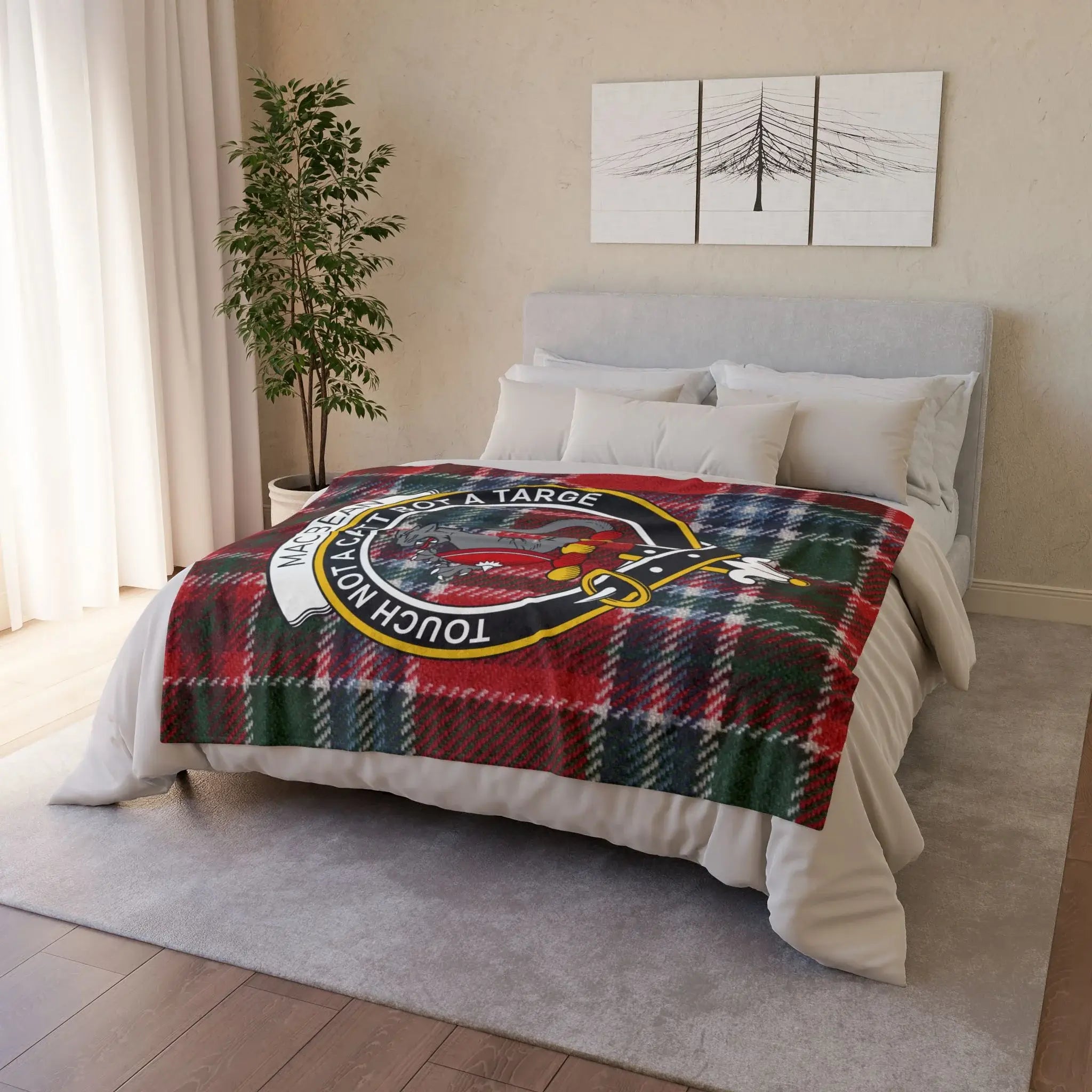 Plaid throw blanket with clan crest on a bed.