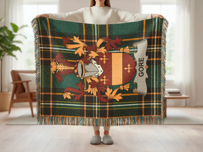 Green plaid blanket with brown and yellow stripes, featuring a crest with the name "Gore".