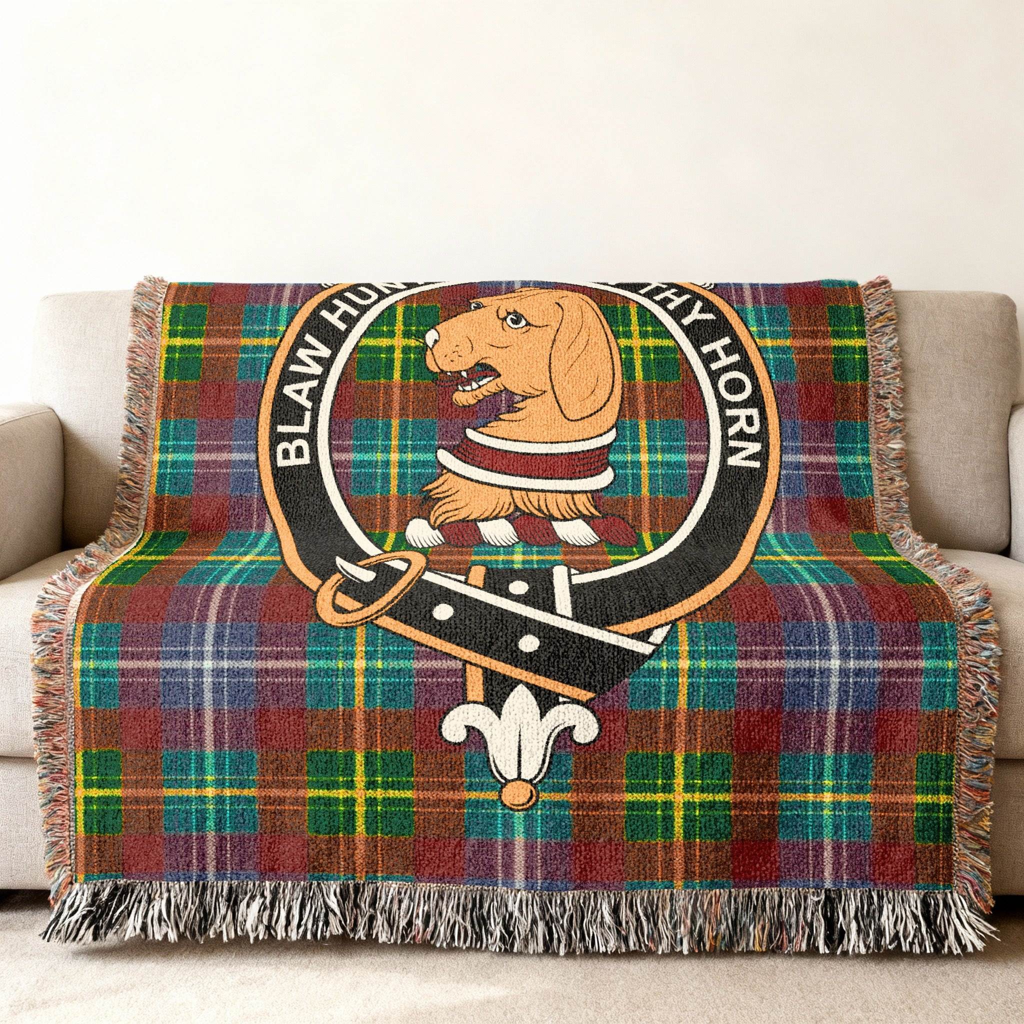 Forrester woven blanket draped over sofa — 60x50 size, fringe edges and clan crest detail
