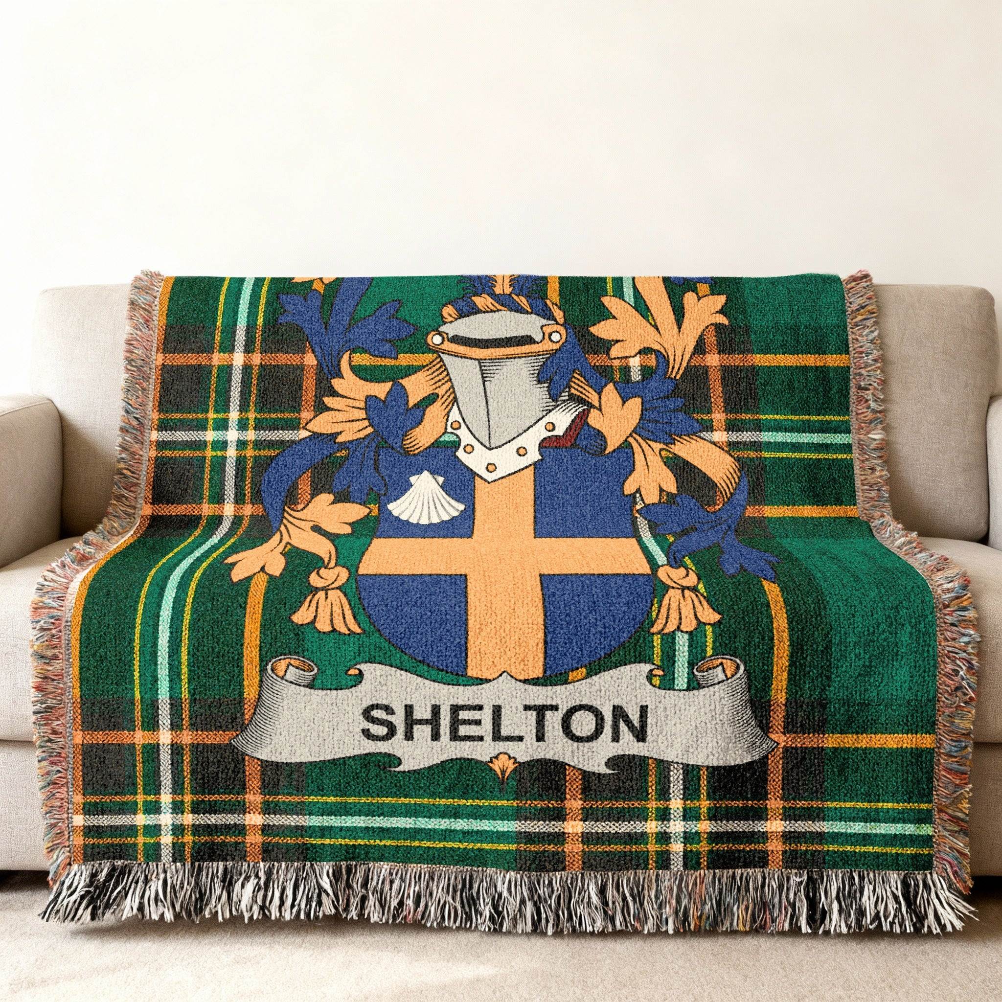 Woven blanket with Shelton family crest and tartan pattern on a sofa.