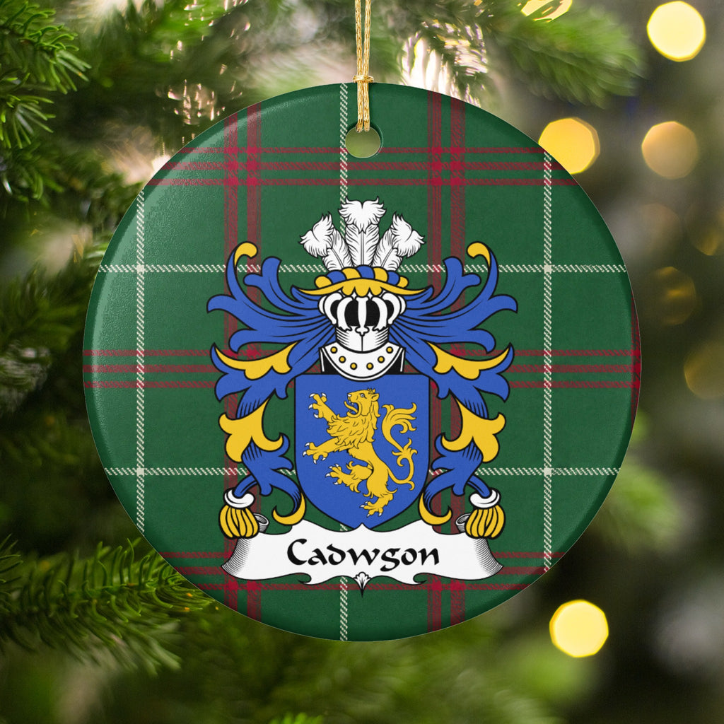Cadwgon Style 2 ornament hanging among Christmas tree branches and warm lights; a gold upright lion on a blue shield on Welsh national tartan.