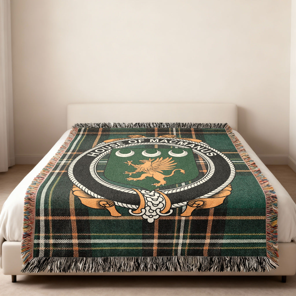 MacManus family crest emblem woven blanket displayed on a bed