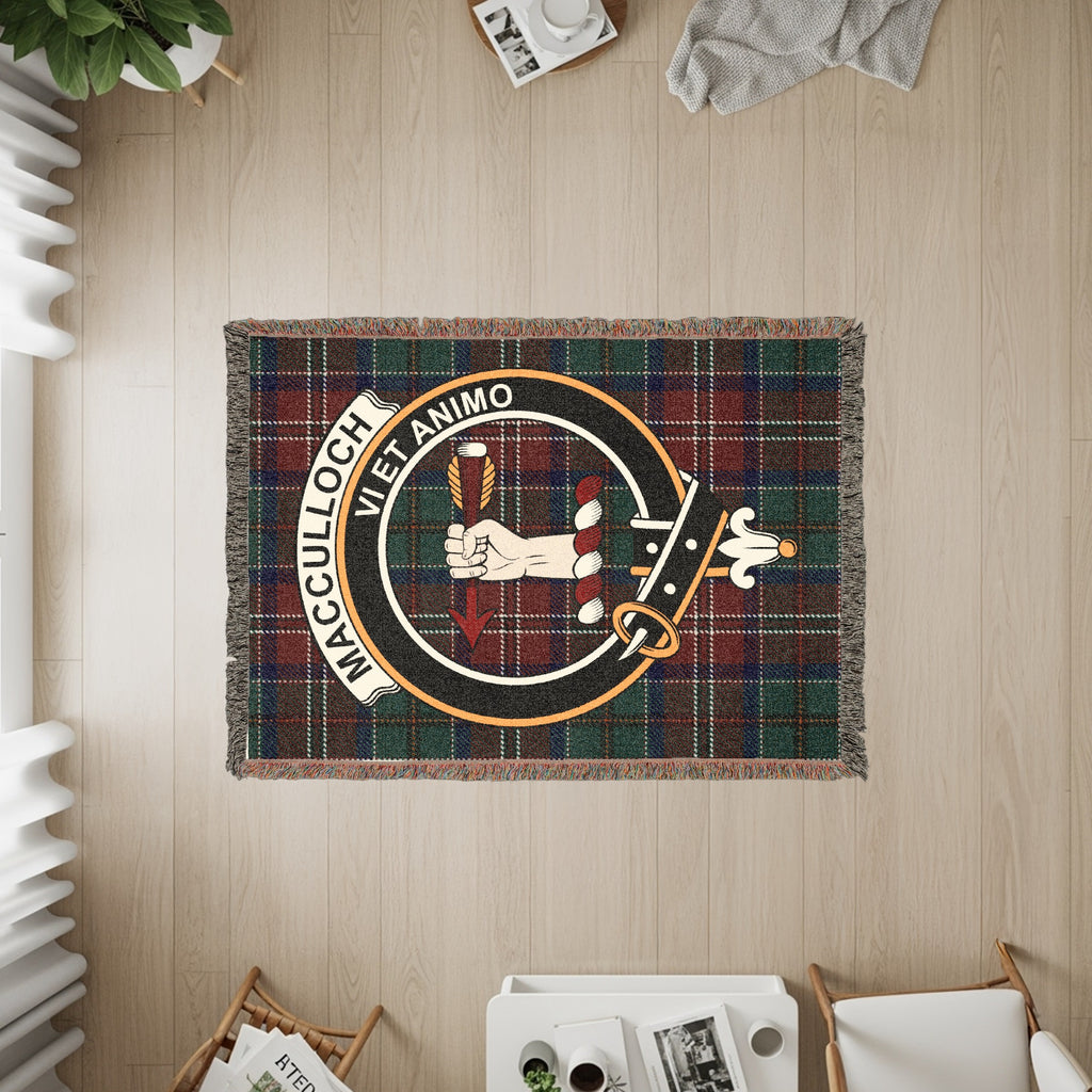 MacCulloch woven blanket displayed on a wall, featuring the crest badge and tartan background