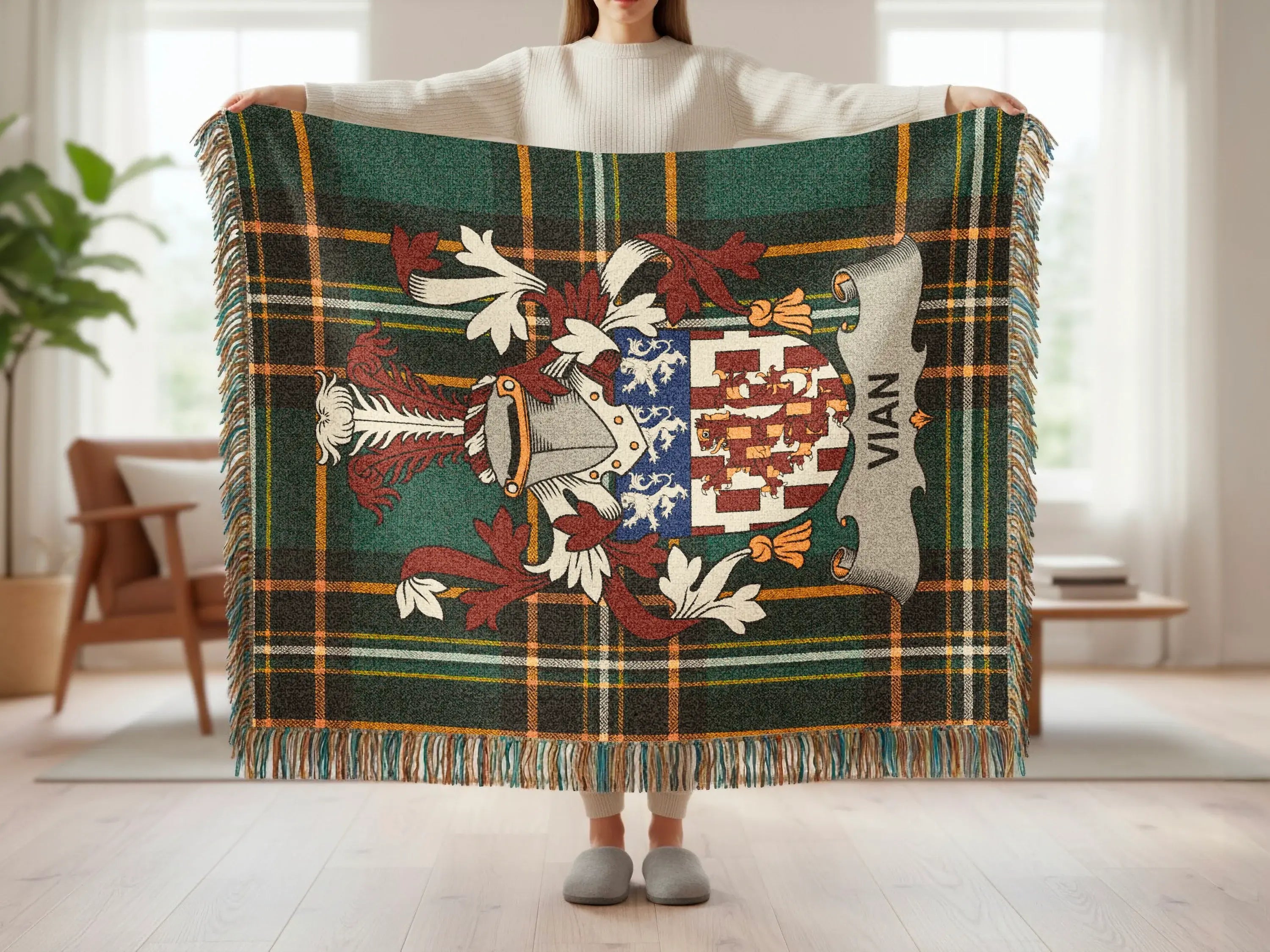 Green tartan blanket with Vian crest held by a person.