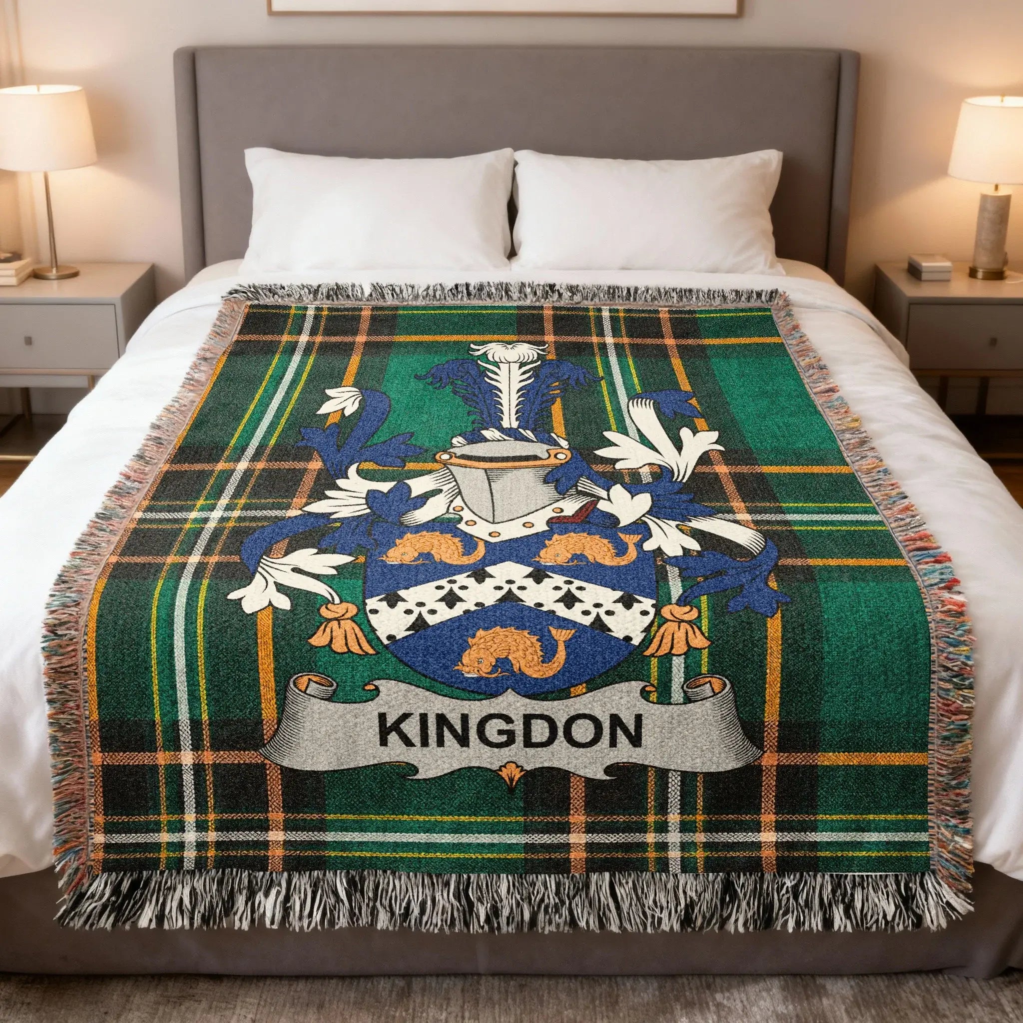 Tartan blanket with Kingdon family crest on a bed.