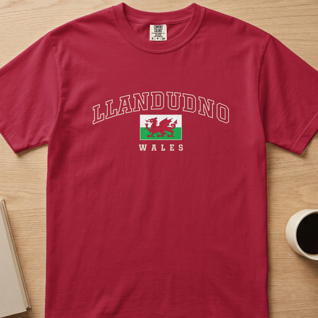 Red Llandudno Wales T-shirt laid flat, with cream collegiate outline lettering and a red Welsh dragon flag.