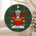 Mercer ornament hanging from a pale wooden branch; three black birds on a jagged gold band above a red shield on Welsh national tartan.