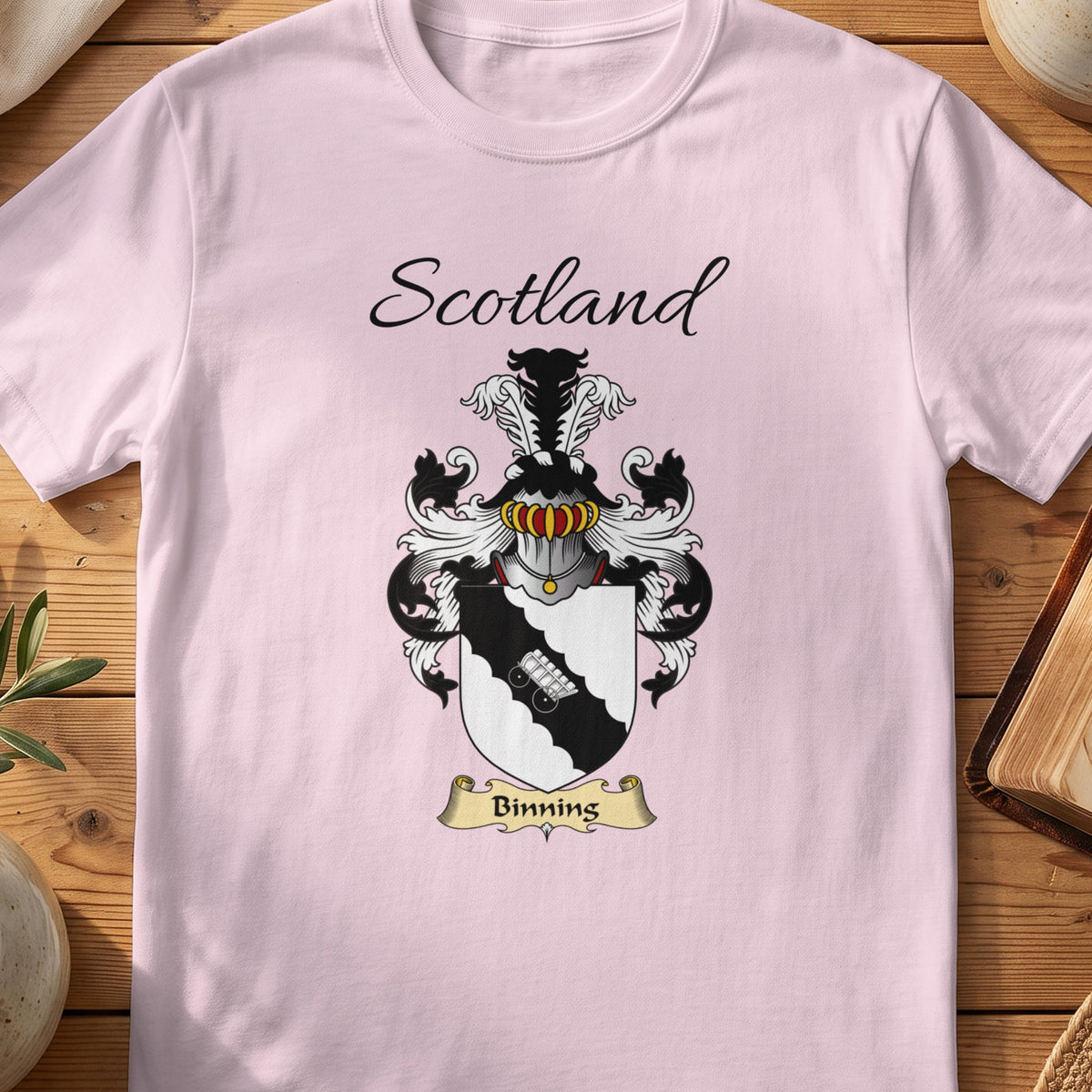 Light Pink Binning Scottish family shield T-shirt featuring a pale linked-hands motif on a black diagonal band