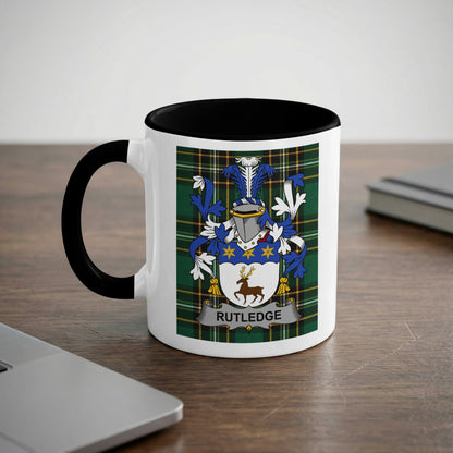 White mug with black handle and interior featuring a Rutledge family crest.
