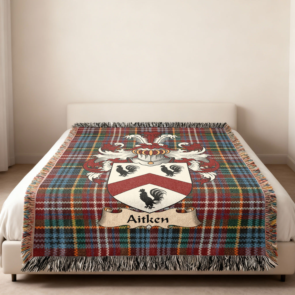 Aitken family crest emblem on a Caledonia tartan woven blanket