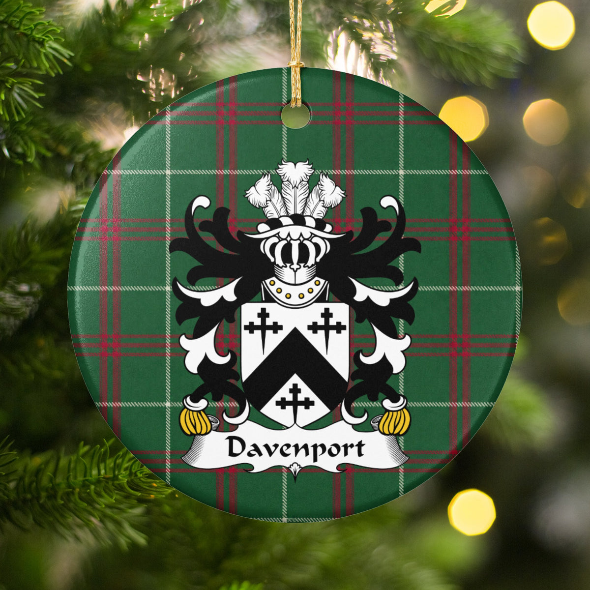 Davenport ornament hanging among Christmas tree branches and warm lights; a black chevron and three black crosses on a white shield on Welsh national tartan.