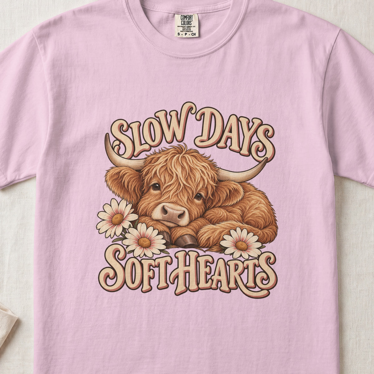 Slow Days, Soft Hearts Highland cow design on a Blossom Comfort Colors 1717 T-shirt, flat lay
