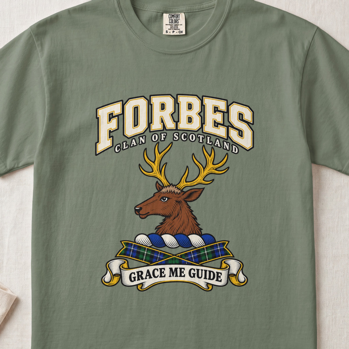 Forbes graphic T-shirt in Moss green, front flat lay showing varsity lettering and brown stag head with gold antlers.