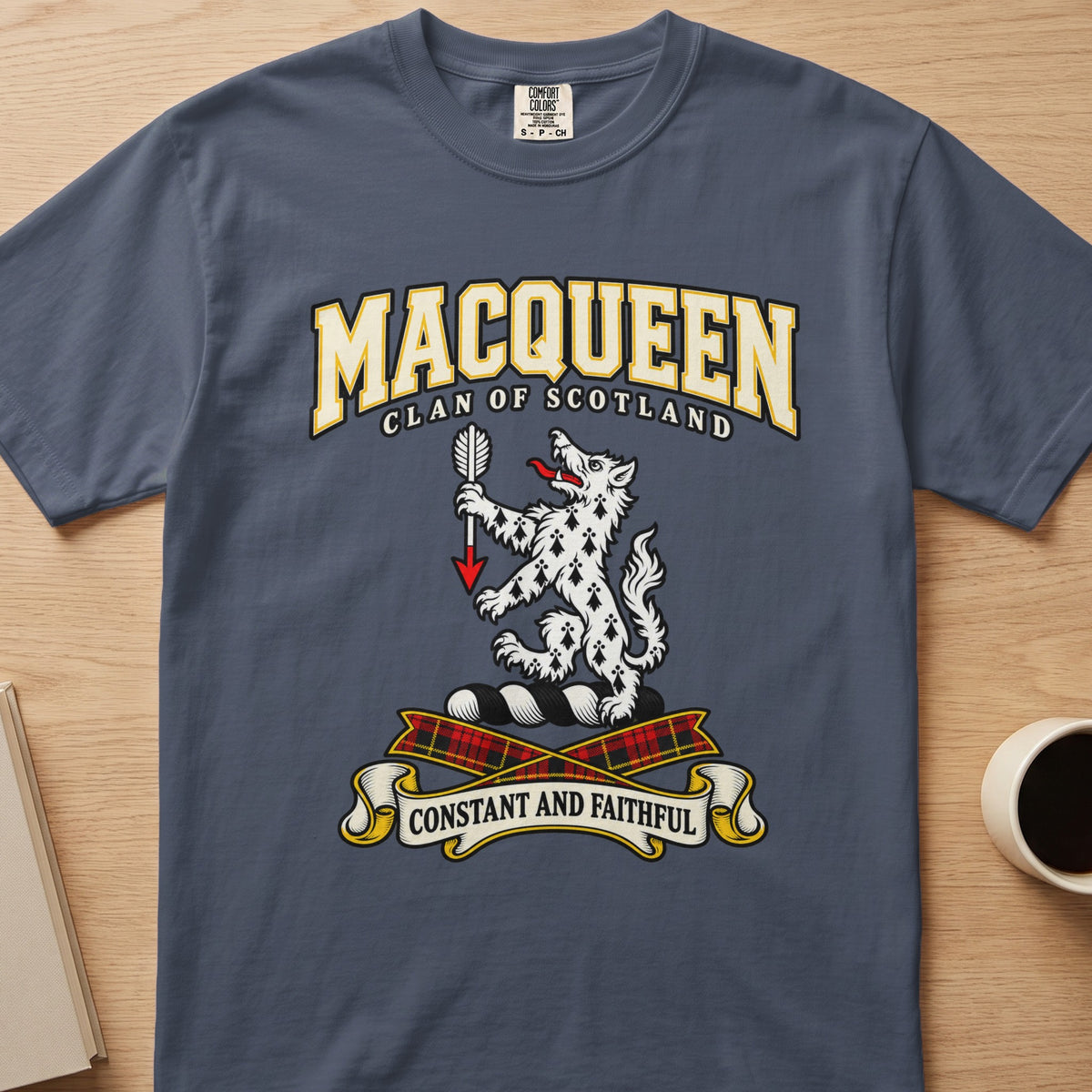 MacQueen white spotted animal crest graphic on a slate blue Comfort Colors T-shirt, front view
