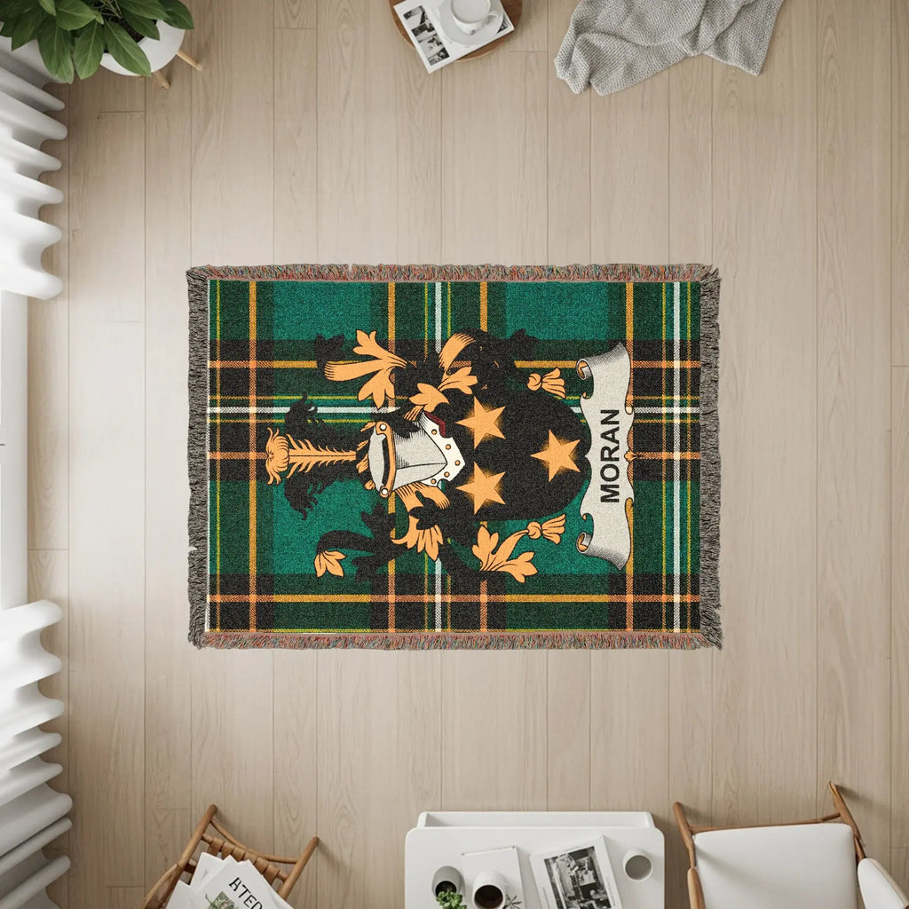 Moran tartan blanket with a crest and fringe, viewed from above.