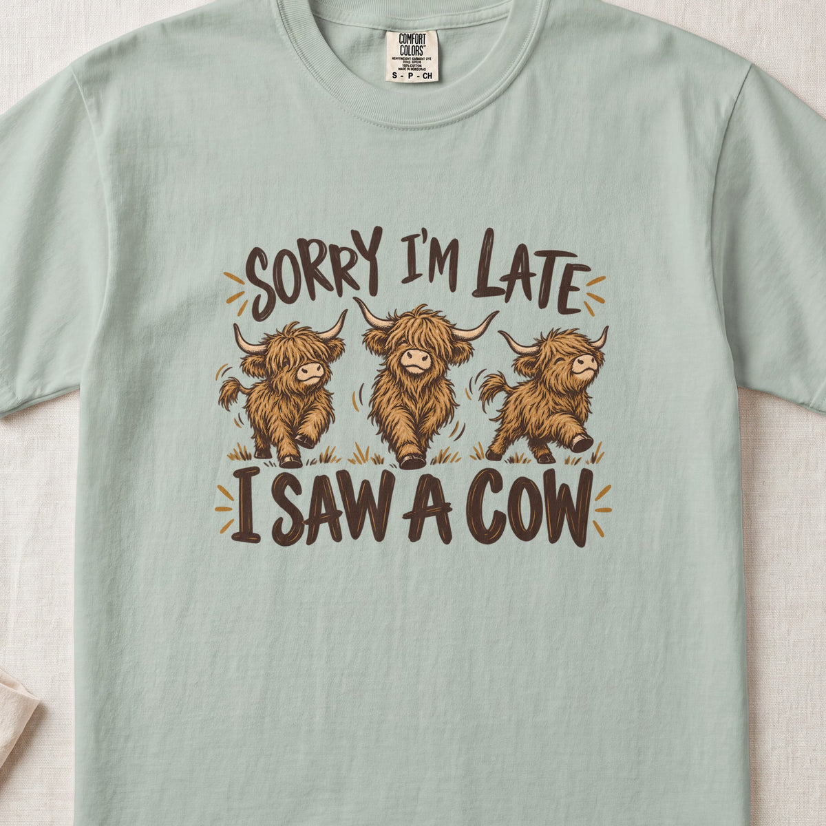 Sorry I'm Late, I Saw a Cow Highland cow design on a Bay Comfort Colors 1717 T-shirt, flat lay