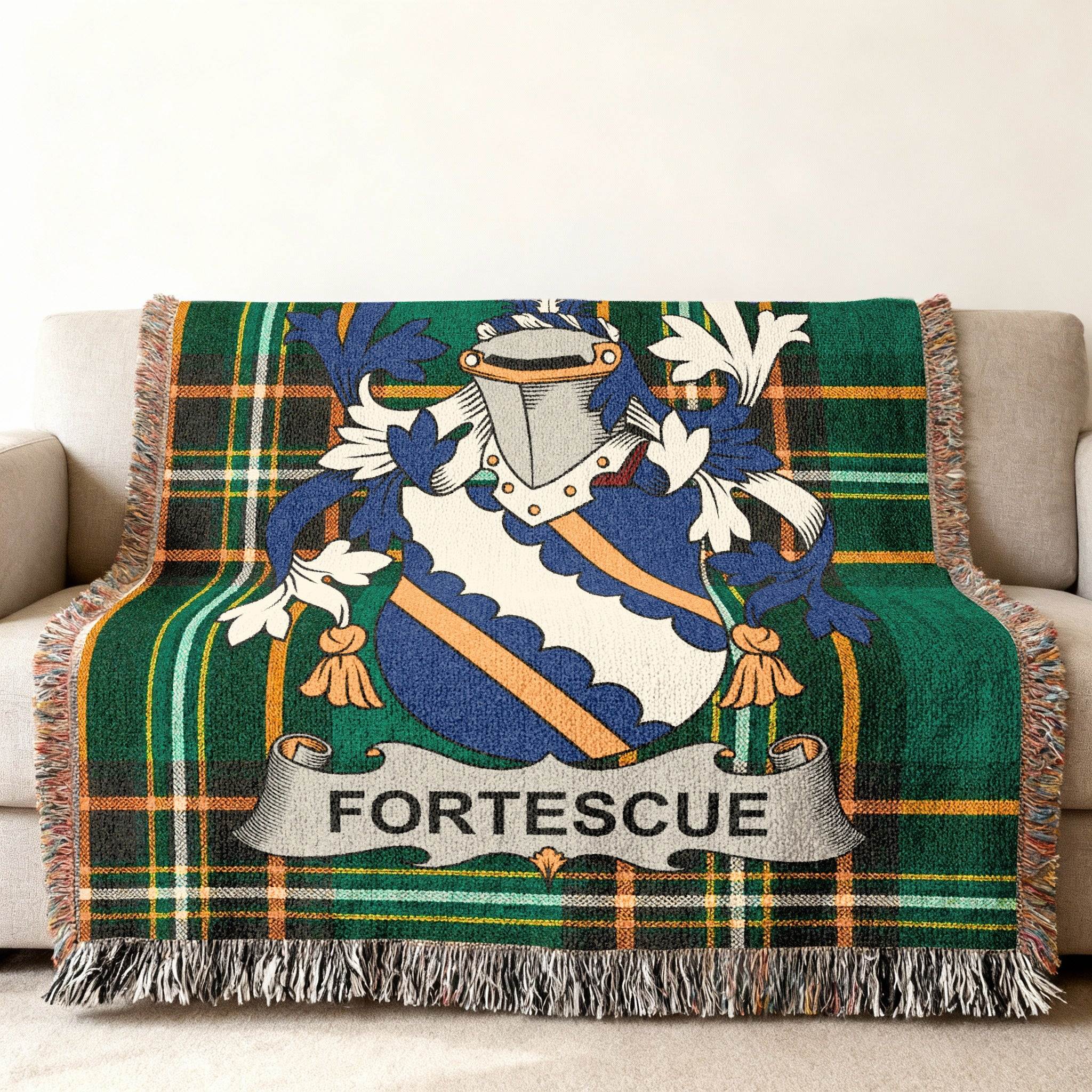 Green plaid throw blanket with Fortescue crest and banner on couch.
