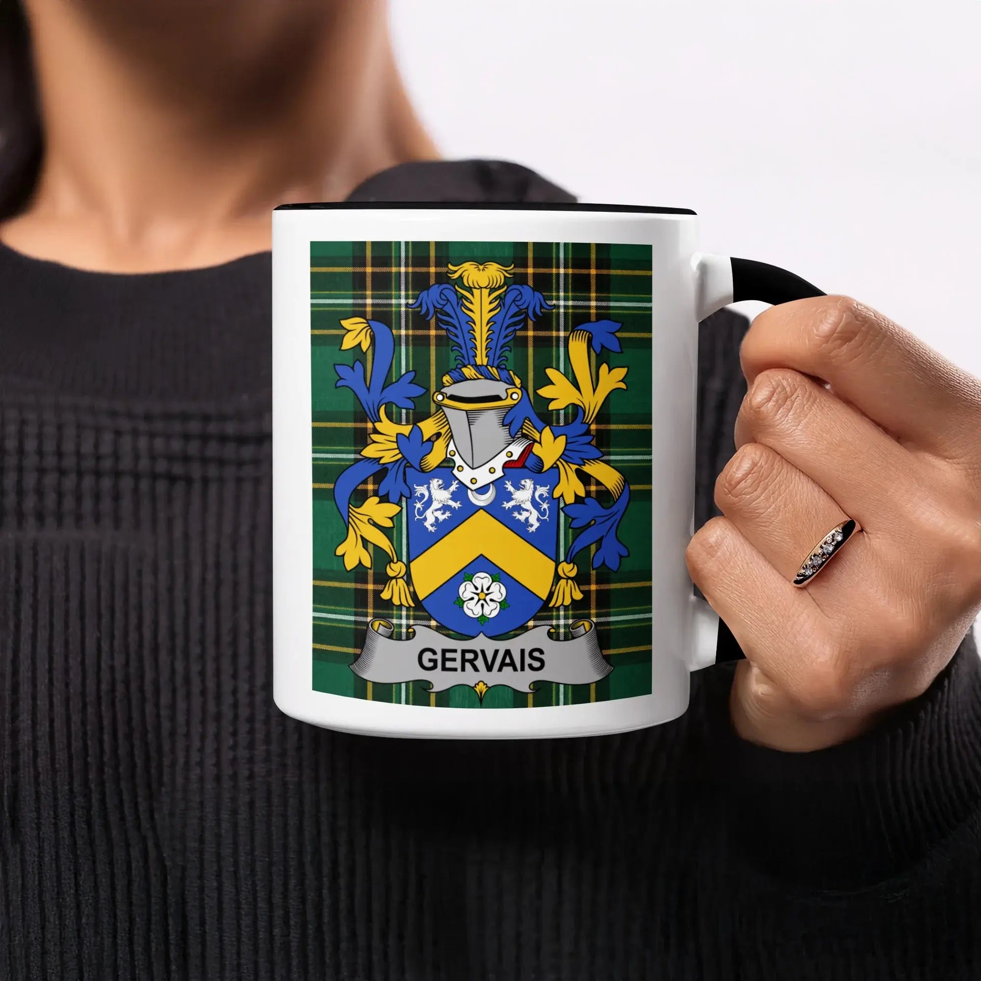 Gervais family crest on a black-rimmed mug held by a person.