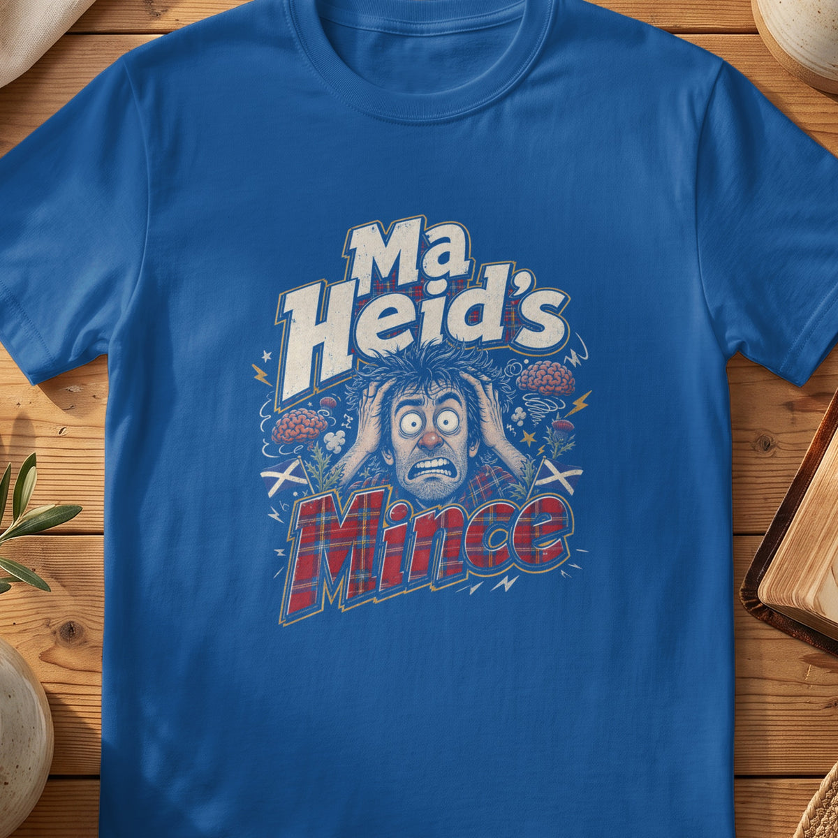 Blue t-shirt with "Ma Heid's Mince" text and distressed Scottish themed graphics.
