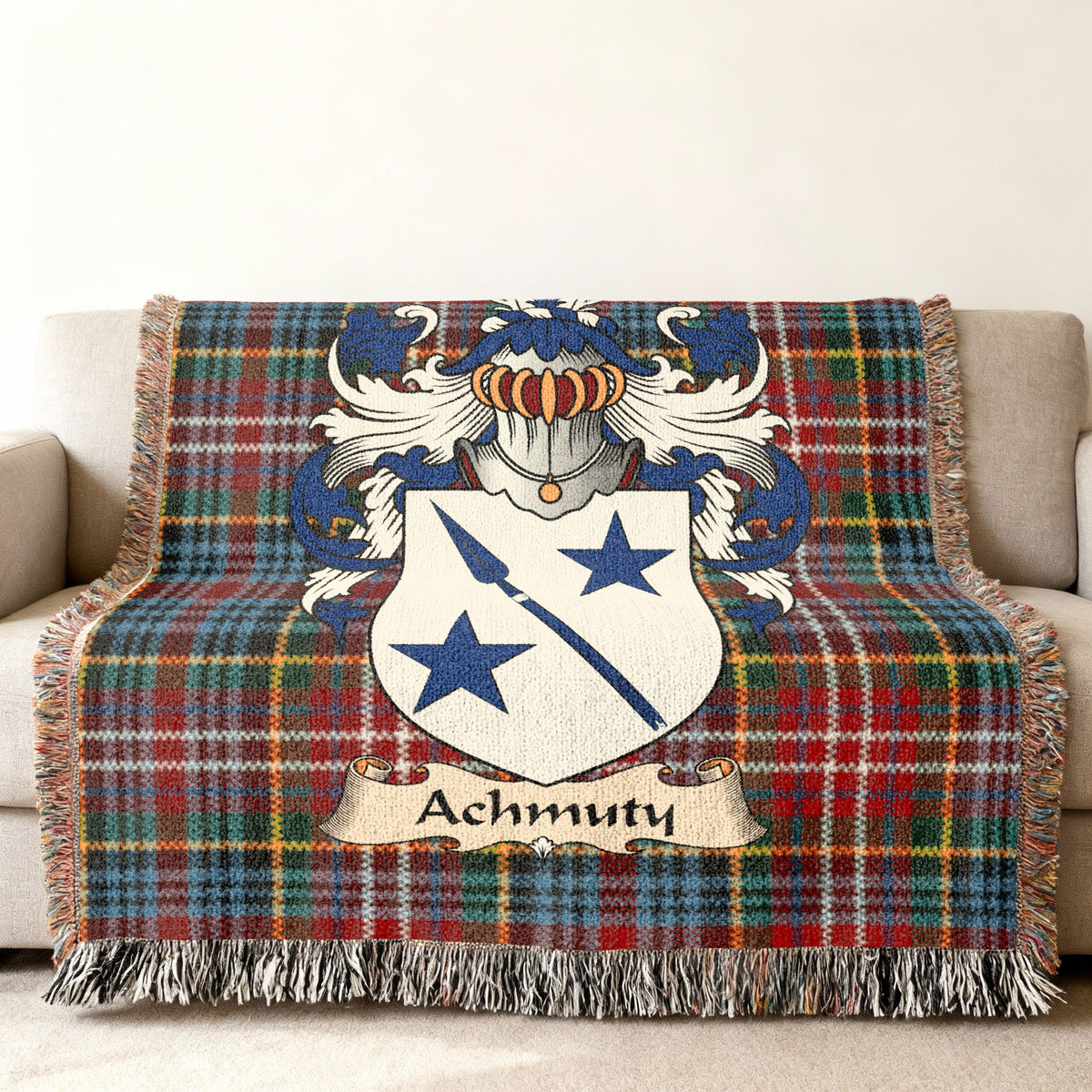 Achmuty Scottish family shield woven blanket with Caledonia tartan background on a sofa