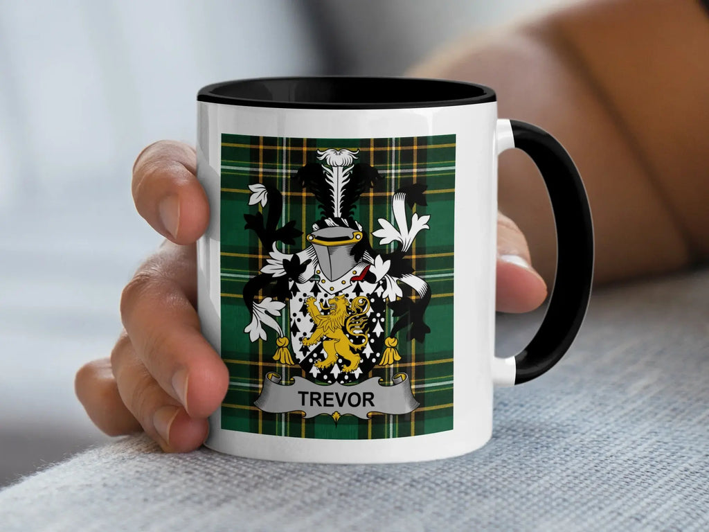 White mug with black handle displaying the Trevor family crest on a tartan background.