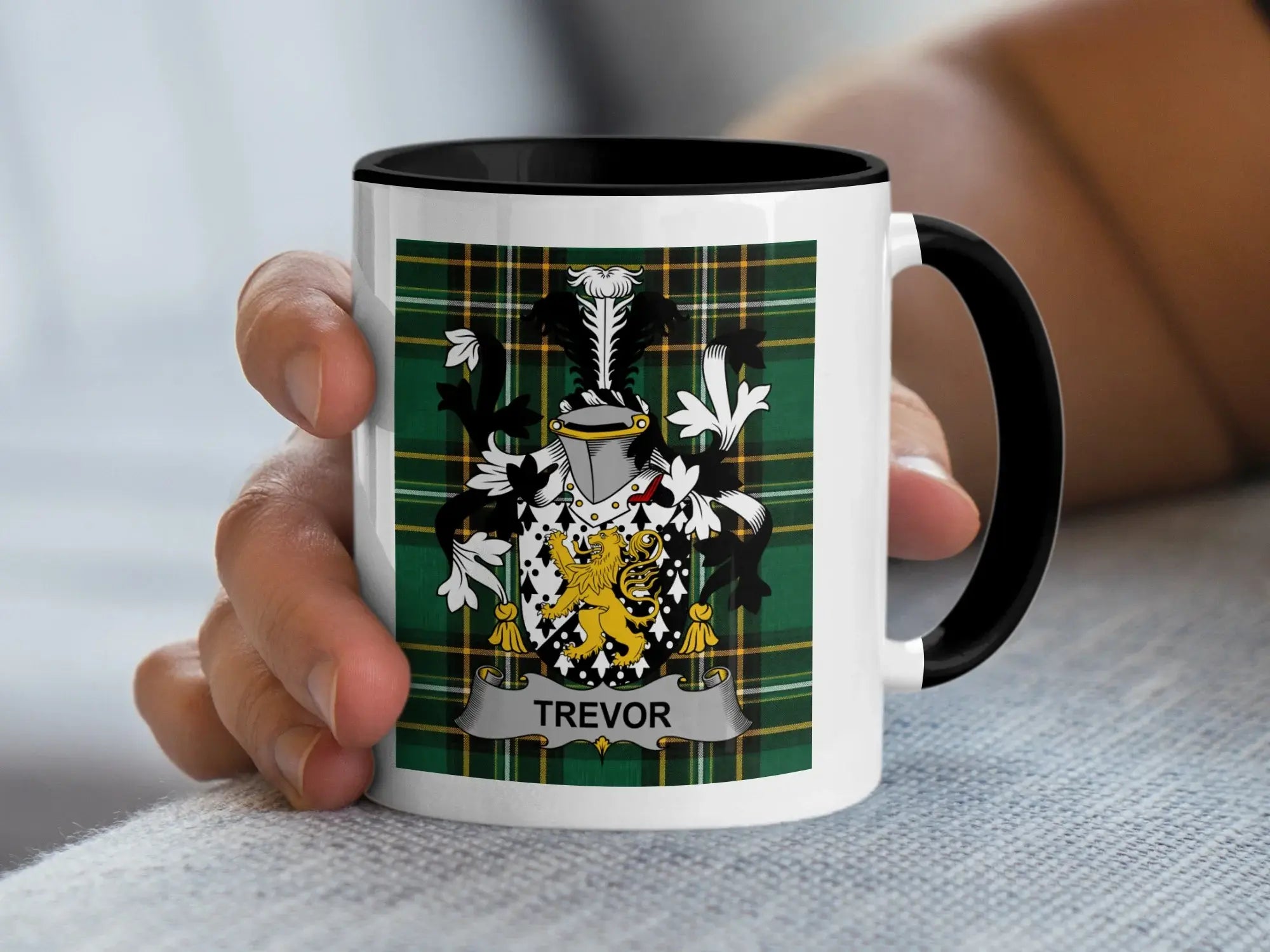 White mug with black handle displaying the Trevor family crest on a tartan background.