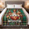 Green tartan blanket with Wickham family crest featuring a shield and crown.