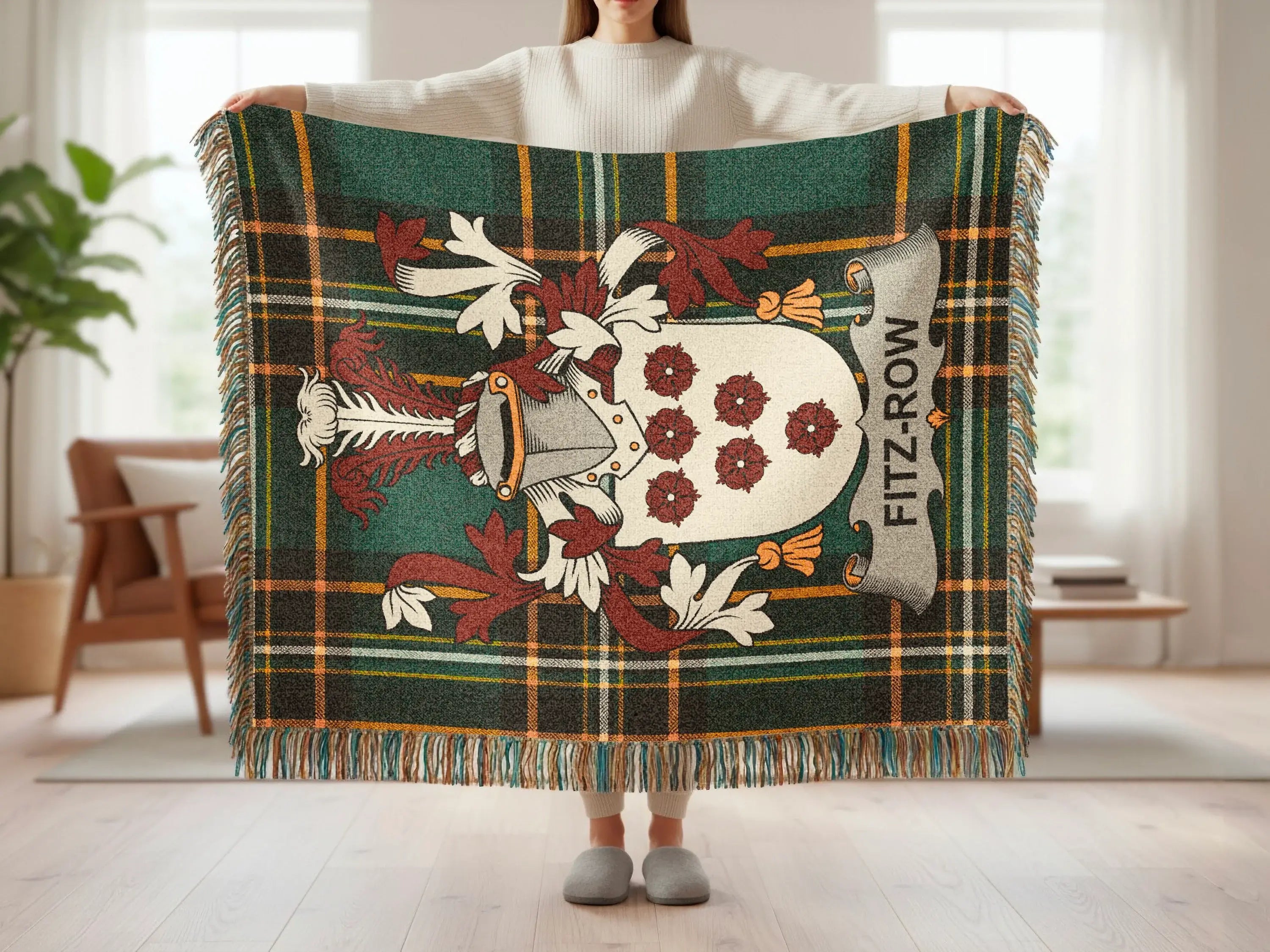 Tartan blanket with Fitz-Row crest displayed by a person.