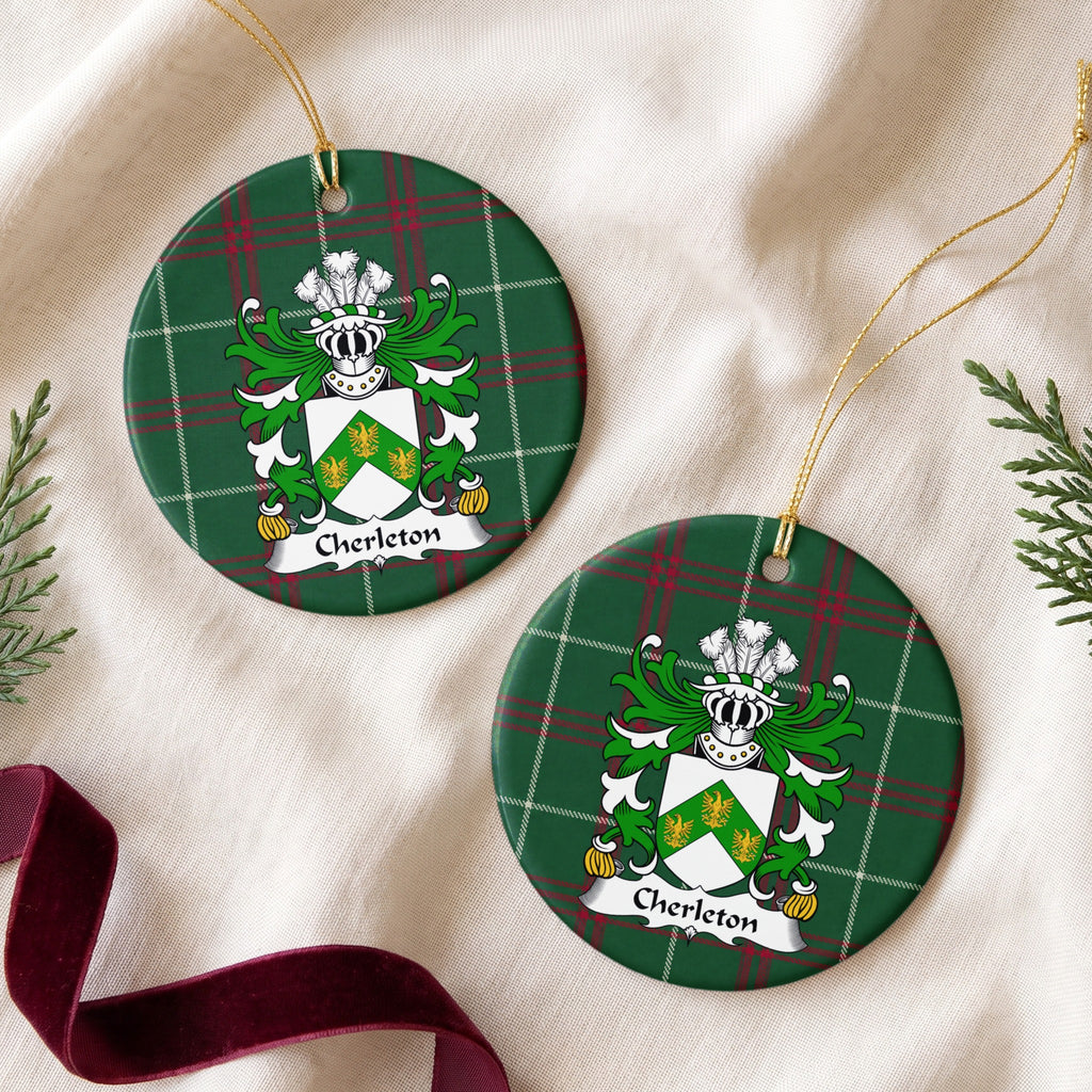 Two Cherleton ornaments on cream fabric beside evergreen sprigs and burgundy ribbon; three gold birds on a green chevron across a white shield on Welsh national tartan.