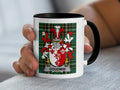 White mug with black rim featuring the Goodwin family crest on a tartan background.