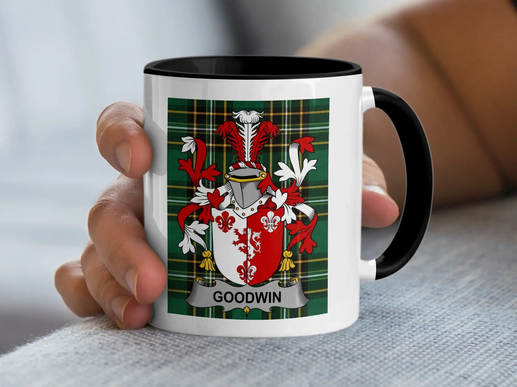 White mug with black rim featuring the Goodwin family crest on a tartan background.