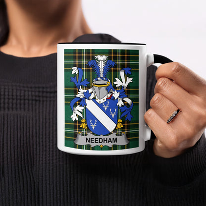 Mug with Needham family crest on green plaid background.