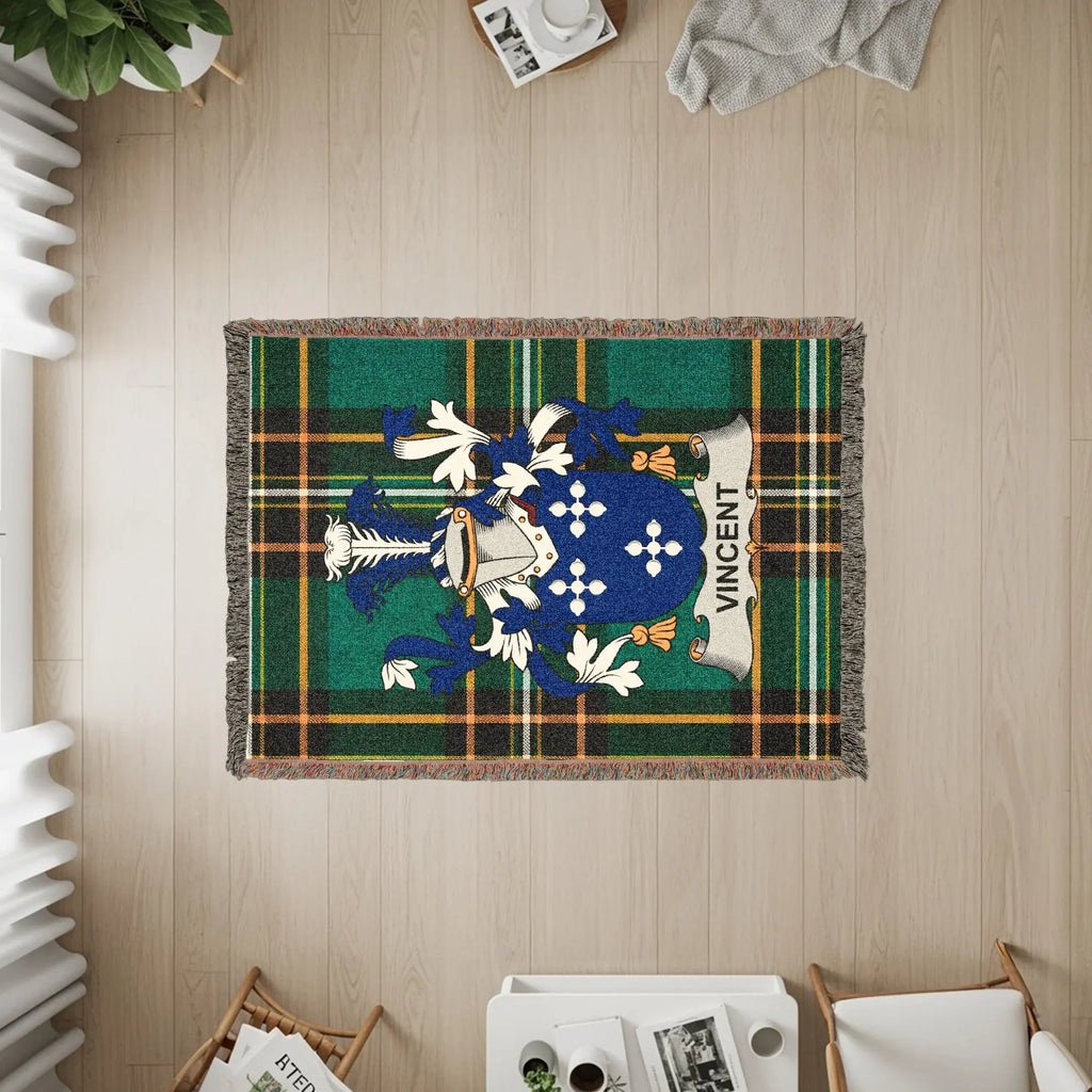 Woven blanket with Vincent family crest on green tartan background.
