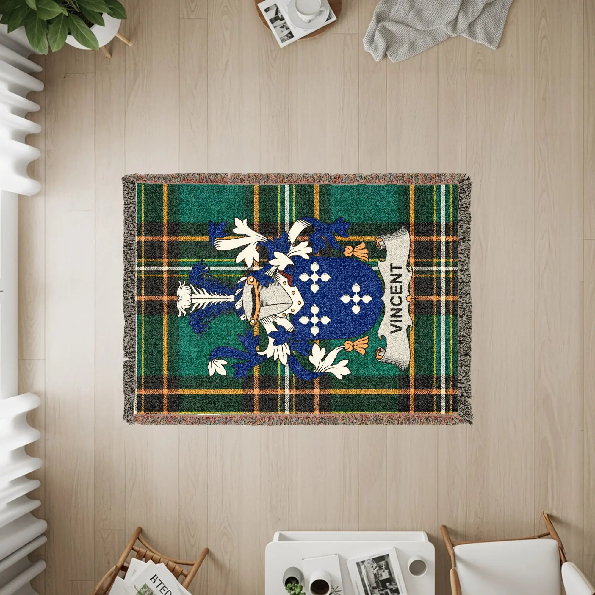 Woven blanket with Vincent family crest on green tartan background.