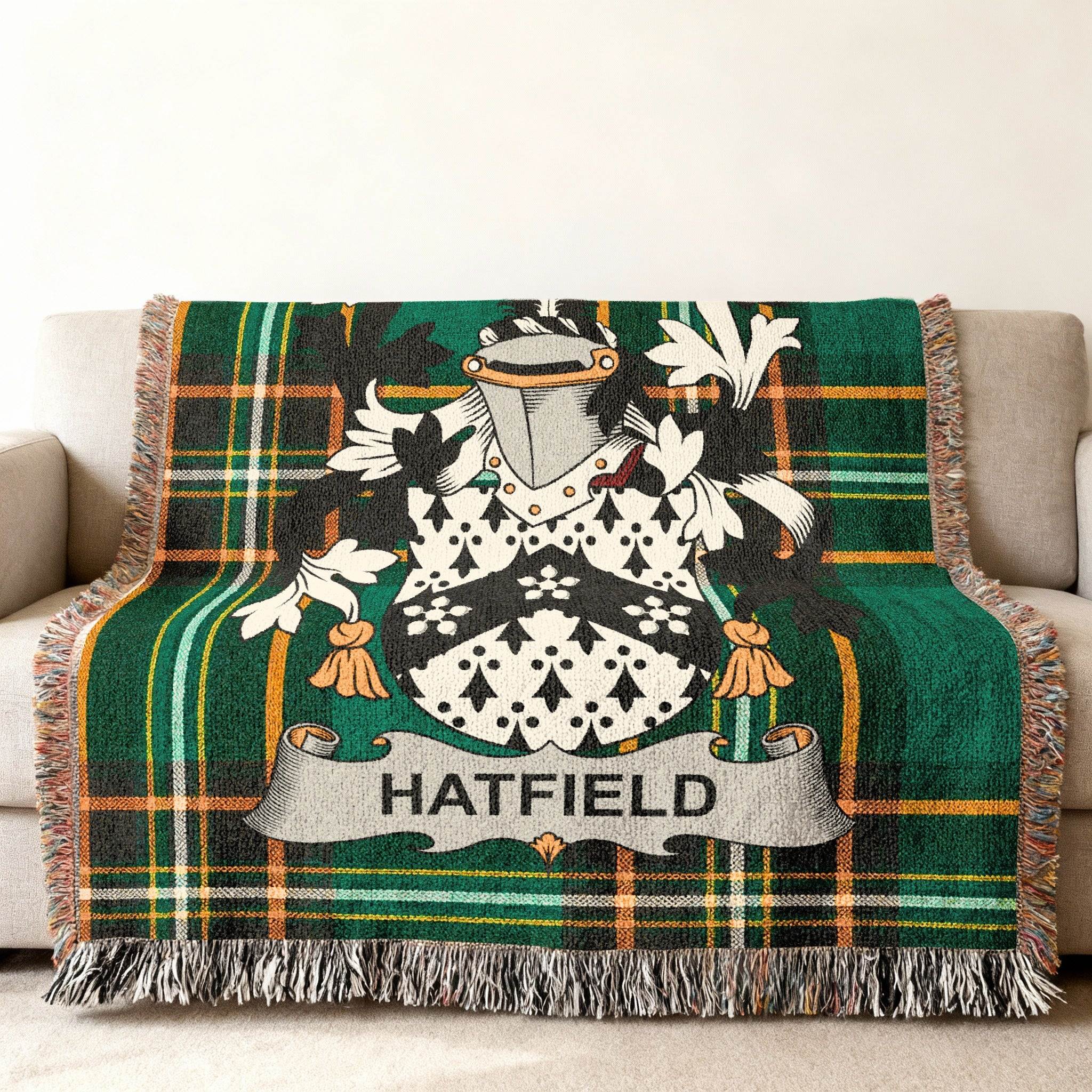 Tartan throw blanket with Hatfield family crest on a couch.