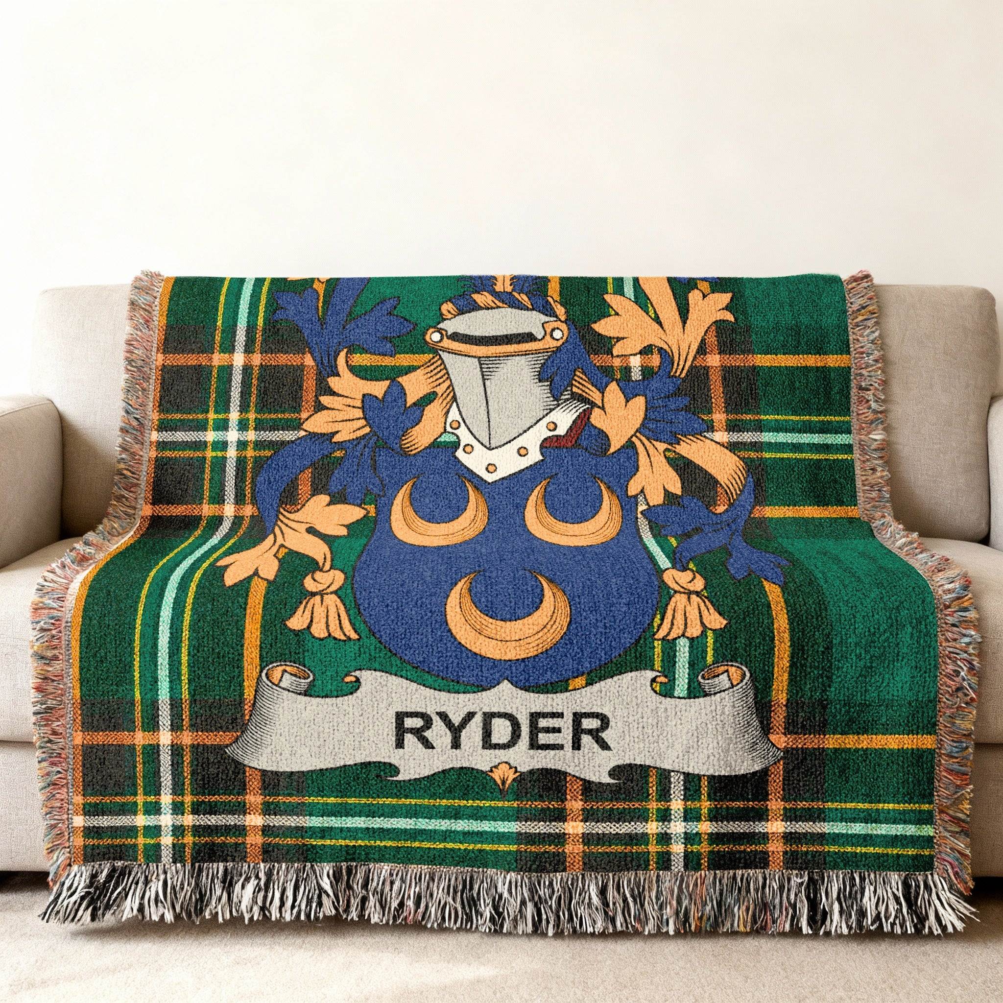 Ryder family crest on green tartan throw blanket draped on sofa.