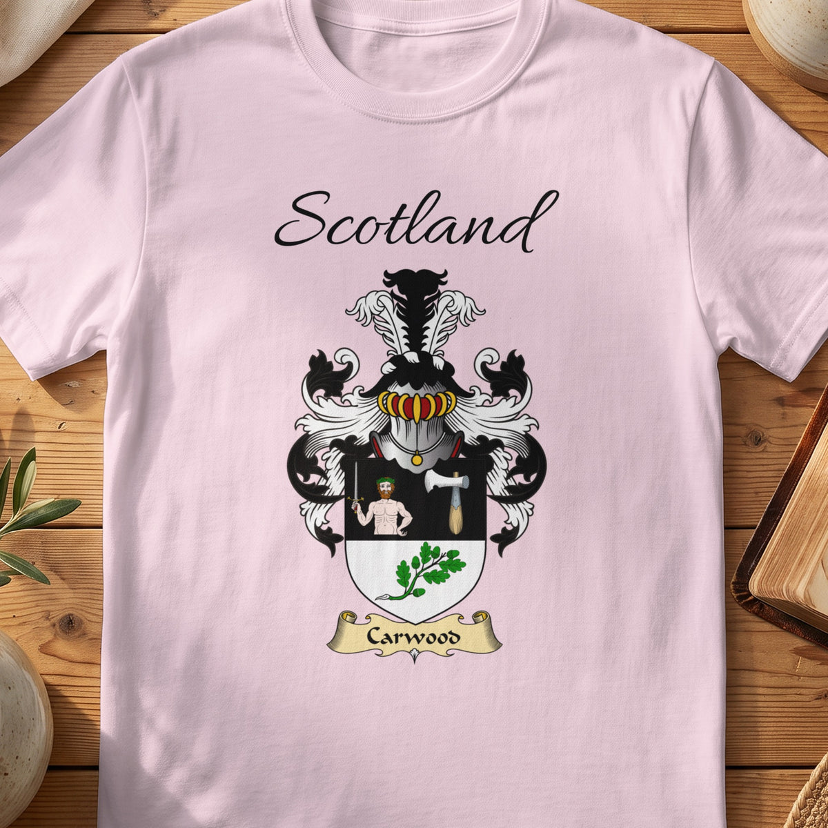 Light Pink Carwood Scottish family shield T-shirt featuring a human figure and axe above green leaves