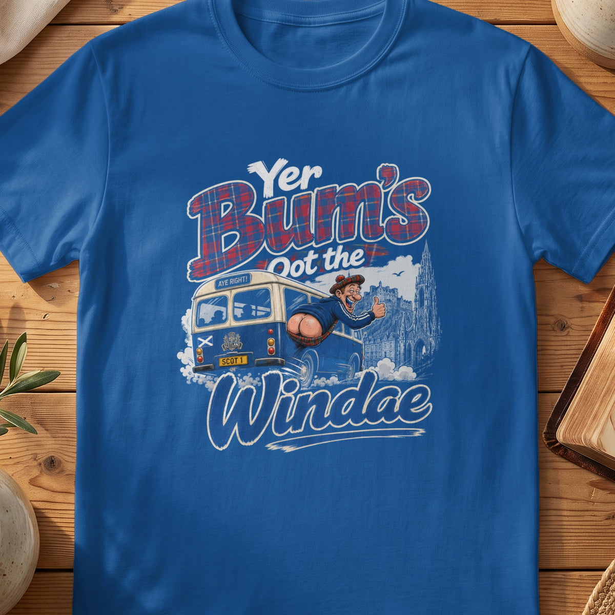 Blue t-shirt with text "Yer Bum's Oot the Windae" and Scottish bus graphic.