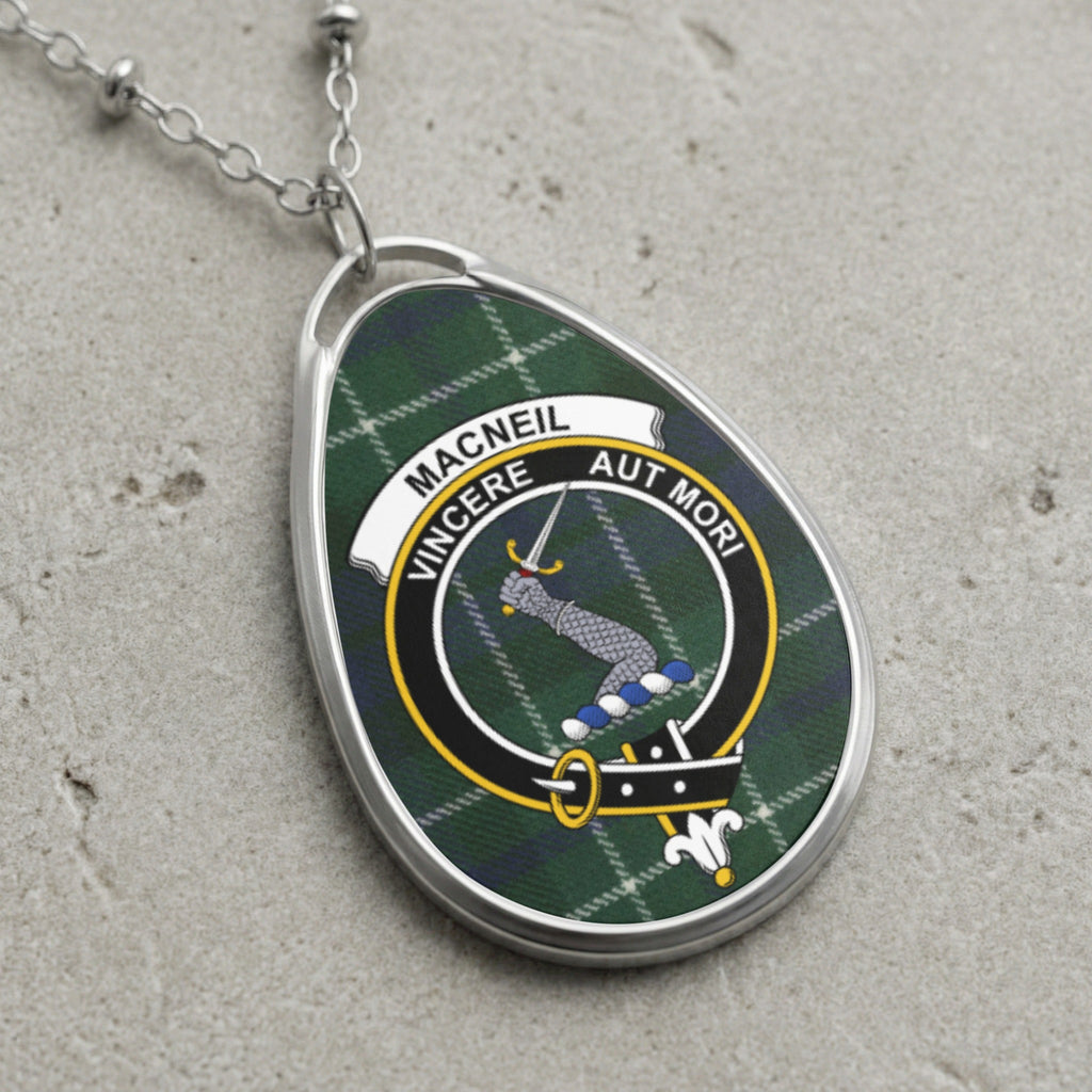 Macneil clan crest pendant on a silver chain with plaid background and "Vincere Aut Mori" motto.