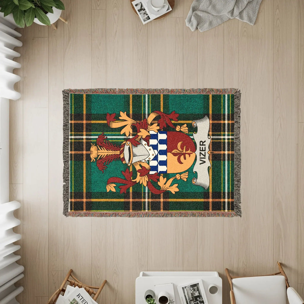 Green and brown plaid woven throw blanket with Vizer family crest.