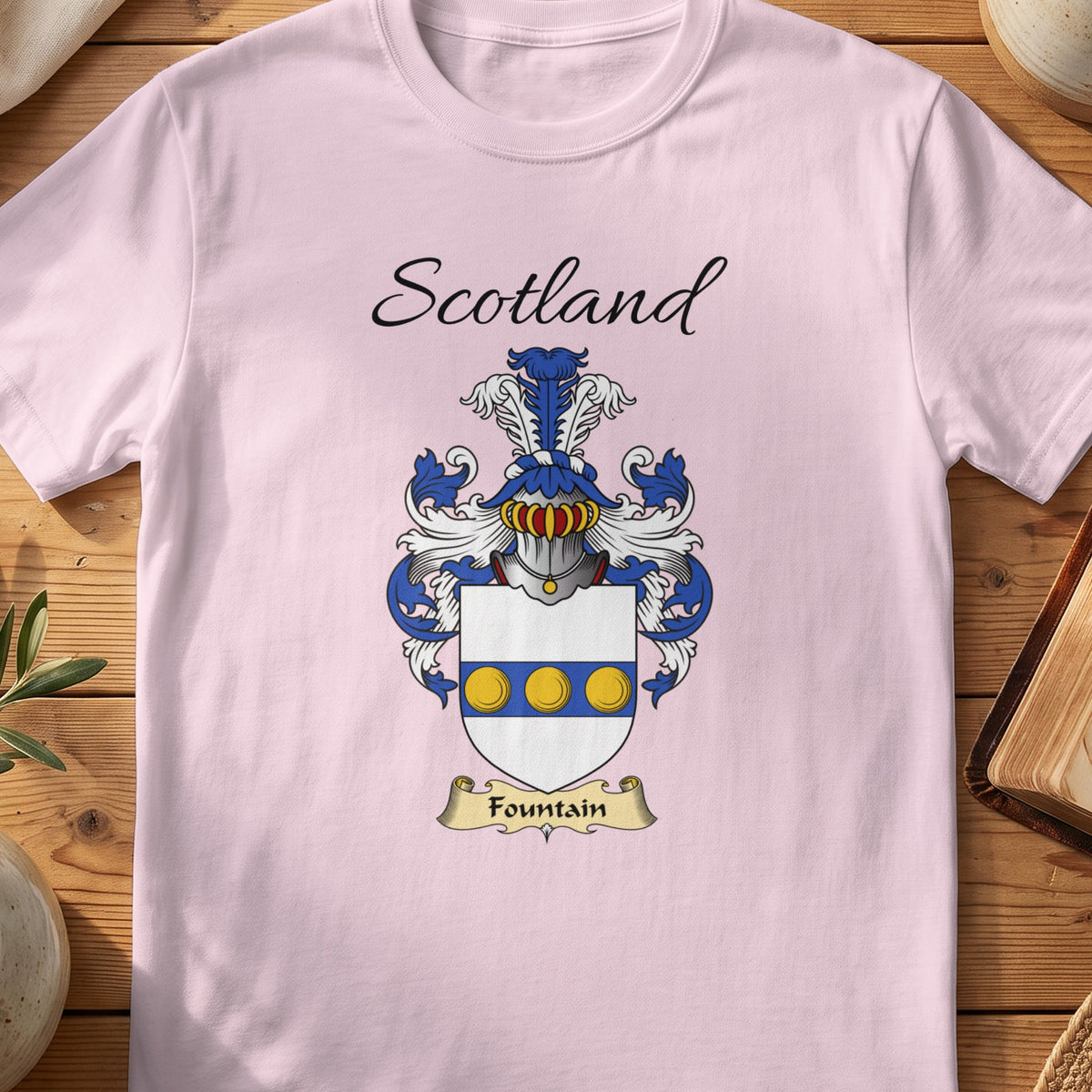 Light Pink Fountain Scottish family shield T-shirt featuring three gold circles along a blue band