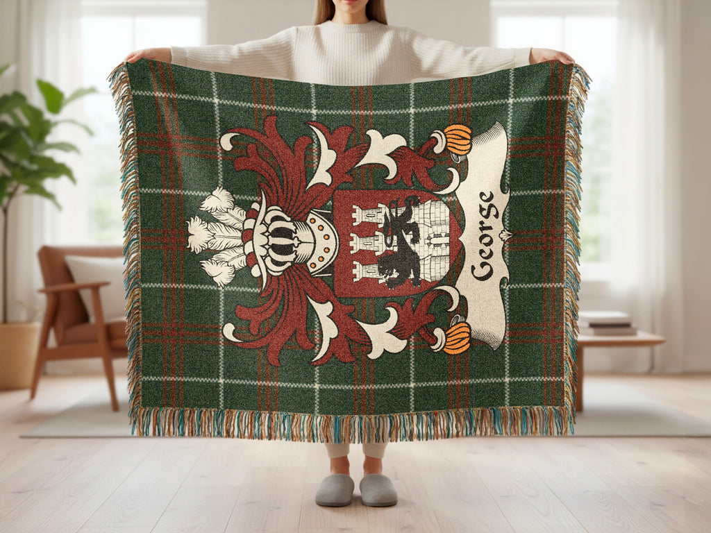 Green tartan throw blanket with a heraldic crest and "George" embroidered.
